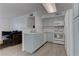 Open kitchen area with white appliances, counter seating and gray laminate flooring at 3103 Key Largo Dr # 103, Las Vegas, NV 89120