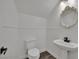 Clean half bathroom featuring a decorative mirror, pedestal sink, and wood-look flooring at 3221 Birdwatcher Ave, North Las Vegas, NV 89084