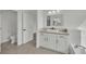 Bathroom featuring white cabinets, a large mirror, and tile flooring at 3221 Birdwatcher Ave, North Las Vegas, NV 89084