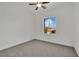 A bright bedroom with carpet flooring, a ceiling fan, and a window with an exterior view at 3221 Birdwatcher Ave, North Las Vegas, NV 89084