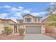 Exterior of a tan two-story home with a two car garage, landscaped front yard and blue skies at 3221 Birdwatcher Ave, North Las Vegas, NV 89084