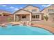 A backyard pool with rock features and a patio, perfect for outdoor relaxation and entertaining at 3221 Birdwatcher Ave, North Las Vegas, NV 89084