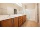 Bathroom featuring double sinks, wood cabinets, and a glass enclosed shower at 3405 Kingbird Dr, North Las Vegas, NV 89084