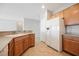 Well-lit kitchen featuring wood cabinets, tile floors, and modern appliances, including a white refrigerator at 3405 Kingbird Dr, North Las Vegas, NV 89084