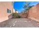 A simple backyard featuring a gravel ground cover, brick walls, and a small tree in a low-maintenance design at 439 Royal Bridge Dr, Las Vegas, NV 89178