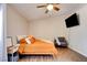 Comfortable bedroom featuring wood floors, ceiling fan, TV, and a cozy chair at 4615 Stearman Dr, North Las Vegas, NV 89031