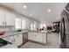 Modern kitchen with granite counters, stainless appliances, and an open view to the living room at 4615 Stearman Dr, North Las Vegas, NV 89031