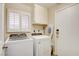 Functional laundry room with a washer, dryer, storage cabinet, and natural light at 4615 Stearman Dr, North Las Vegas, NV 89031