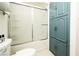 Clean, white bathroom with tub, shower, toilet, and blue cabinet for extra storage at 4742 Monterrey Ave, Las Vegas, NV 89121