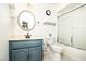 Well-lit bathroom features a blue vanity, decorative mirror, toilet, and tub/shower combo at 4742 Monterrey Ave, Las Vegas, NV 89121
