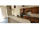 Open kitchen with breakfast bar, wooden cabinets, built-in oven, and stone flooring at 4821 Whisper Lake Ave, Las Vegas, NV 89131