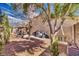 View of the backyard with a covered patio, desert landscaping, and trees at 4910 Marywood Ct, Pahrump, NV 89061