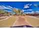 Expansive backyard featuring custom desert landscaping with gravel, trees, and a brick pathway at 4910 Marywood Ct, Pahrump, NV 89061