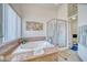 Luxurious bathroom with a relaxing soaking tub, a separate glass shower, and a bright window with privacy blinds at 4910 Marywood Ct, Pahrump, NV 89061