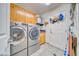 Well-lit laundry room with modern washer and dryer, upper cabinets, and functional door storage at 4910 Marywood Ct, Pahrump, NV 89061
