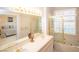 Bright bathroom featuring a dual vanity and bathtub with shower, creating a spa-like atmosphere at 4911 Mount Pleasant Ln, Las Vegas, NV 89113