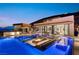 Modern backyard oasis with a luxurious pool, lounge seating, and outdoor kitchen, perfect for relaxation and entertainment at 507 Serenity Point Dr, Henderson, NV 89012