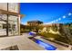 Serene backyard featuring a modern fire pit, water feature, and lush landscaping for ultimate privacy at 507 Serenity Point Dr, Henderson, NV 89012