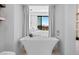 Elegant bathroom featuring a freestanding tub with mountain views through a large window at 507 Serenity Point Dr, Henderson, NV 89012
