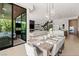 Open concept dining area with modern lighting, outdoor access, and views of the backyard and living room at 507 Serenity Point Dr, Henderson, NV 89012