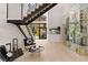 Grand foyer with floating staircase, floor-to-ceiling wine storage, and modern architectural details at 507 Serenity Point Dr, Henderson, NV 89012
