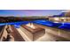 Relax by the glowing pool and modern fire feature with stunning views of the city skyline at dusk at 507 Serenity Point Dr, Henderson, NV 89012