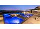 An illuminated pool with integrated spa and fire pit, and outdoor entertaining area with city lights at night at 507 Serenity Point Dr, Henderson, NV 89012