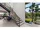 Modern staircase with sleek design, bright natural light, and views of the outdoor living space with mature landscaping at 507 Serenity Point Dr, Henderson, NV 89012