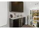 Modern wet bar featuring custom cabinets, a marble countertop, and a wine refrigerator at 507 Serenity Point Dr, Henderson, NV 89012