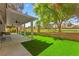 The backyard features a covered patio, artificial turf, and mature landscaping at 5157 Future Dr, Las Vegas, NV 89130