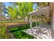 Backyard featuring a covered patio, manicured lawn, privacy fence, and lush landscaping at 5157 Future Dr, Las Vegas, NV 89130