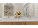 Bright bathroom with double sinks, marble countertops, wooden cabinets, and decorative gold mirrors at 5157 Future Dr, Las Vegas, NV 89130