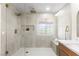 Bright bathroom with a glass enclosed shower with double shower heads, tiled walls, and white marble countertops at 5157 Future Dr, Las Vegas, NV 89130