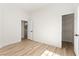 A bright bedroom with an open closet and wood-look flooring and a view into another room at 5157 Future Dr, Las Vegas, NV 89130