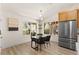 Bright dining area with stainless fridge, and an eye-catching light fixture illuminating the modern table set at 5157 Future Dr, Las Vegas, NV 89130