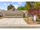 Home exterior with a two-car garage, mature trees, and a for sale sign in the front yard at 5157 Future Dr, Las Vegas, NV 89130