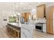 Modern kitchen featuring an island with marble countertops and seating, complemented by wooden cabinetry at 5157 Future Dr, Las Vegas, NV 89130