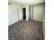 A bedroom features a built-in shelving unit, carpeted floors and white painted walls at 5243 Sunnywood Dr, Las Vegas, NV 89120