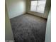 Bright bedroom with neutral carpet and a large window provides natural light at 5243 Sunnywood Dr, Las Vegas, NV 89120