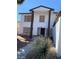 Front view of a two-story home with dark trim, contrasting the light exterior, and desert landscaping at 5243 Sunnywood Dr, Las Vegas, NV 89120