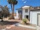 Two-story home with a front yard, featuring desert landscaping, palm trees, and an attached garage at 5243 Sunnywood Dr, Las Vegas, NV 89120