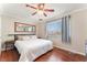 Inviting bedroom featuring wood floors, a ceiling fan, and a large window for natural light at 5505 Reiter Ave, Las Vegas, NV 89108