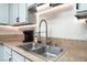 Close-up of the kitchen sink with stainless steel appliances, granite counters and white cabinets at 5505 Reiter Ave, Las Vegas, NV 89108