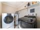 Functional laundry room with modern washer and dryer units and overhead shelving at 5505 Reiter Ave, Las Vegas, NV 89108