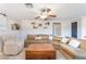 View of the living room with a large sectional sofa, ceiling fan, and decor shelves at 5505 Reiter Ave, Las Vegas, NV 89108