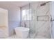 Bathroom with soaking tub and glass-enclosed shower with marble-look tile at 5653 Artesia Lake Ct, Las Vegas, NV 89118