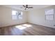 Bedroom featuring wood-look floors, ceiling fan, and two windows for natural light at 5653 Artesia Lake Ct, Las Vegas, NV 89118