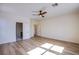 Open bedroom with wood-look floors, ceiling fan, and multiple doors at 5653 Artesia Lake Ct, Las Vegas, NV 89118