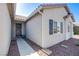 Inviting home entrance with a dark-stained door, desert landscaping, and covered porch at 5653 Artesia Lake Ct, Las Vegas, NV 89118