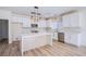 Modern kitchen featuring stainless steel appliances, white cabinets, and a center island with a herringbone pattern at 5653 Artesia Lake Ct, Las Vegas, NV 89118